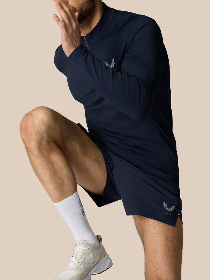 Athlete wearing Zone Training 1/4 Zip Top in Midnight Navy with high neck and zip closure
