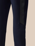Full-body view of man in navy Flex Thermo Pant tracksuit with side stripe and Castore logo on the leg.