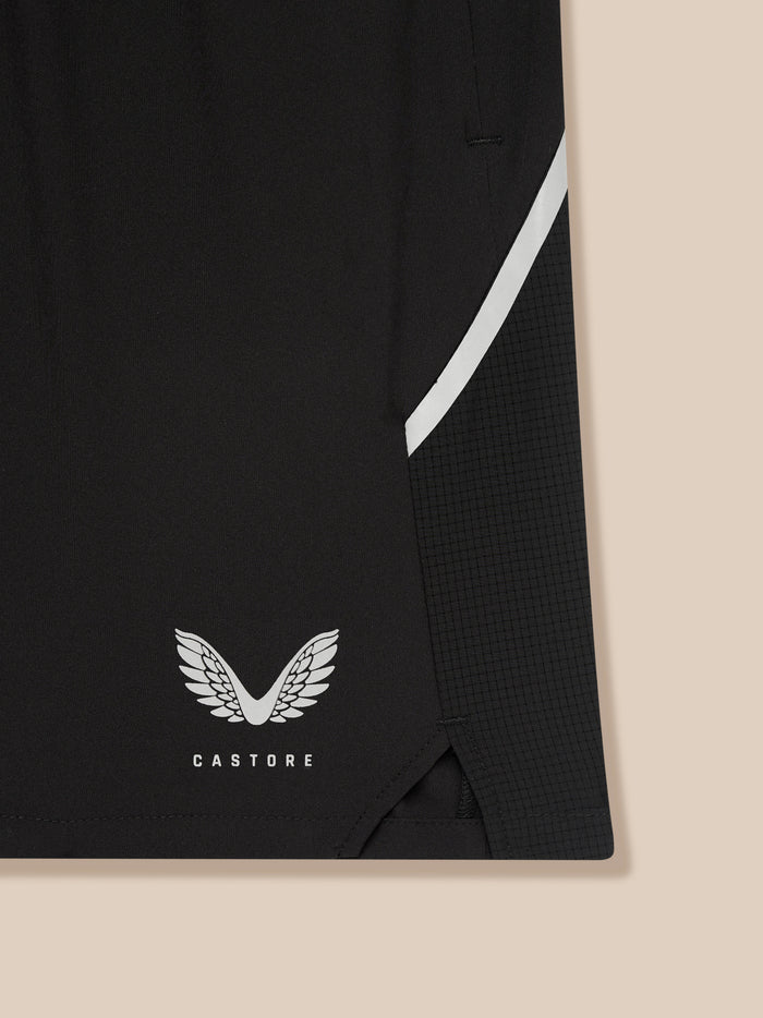 Close up of black Apex Training 6 inch shorts fabric showing a white diagonal stripe and the Castore wing logo.
