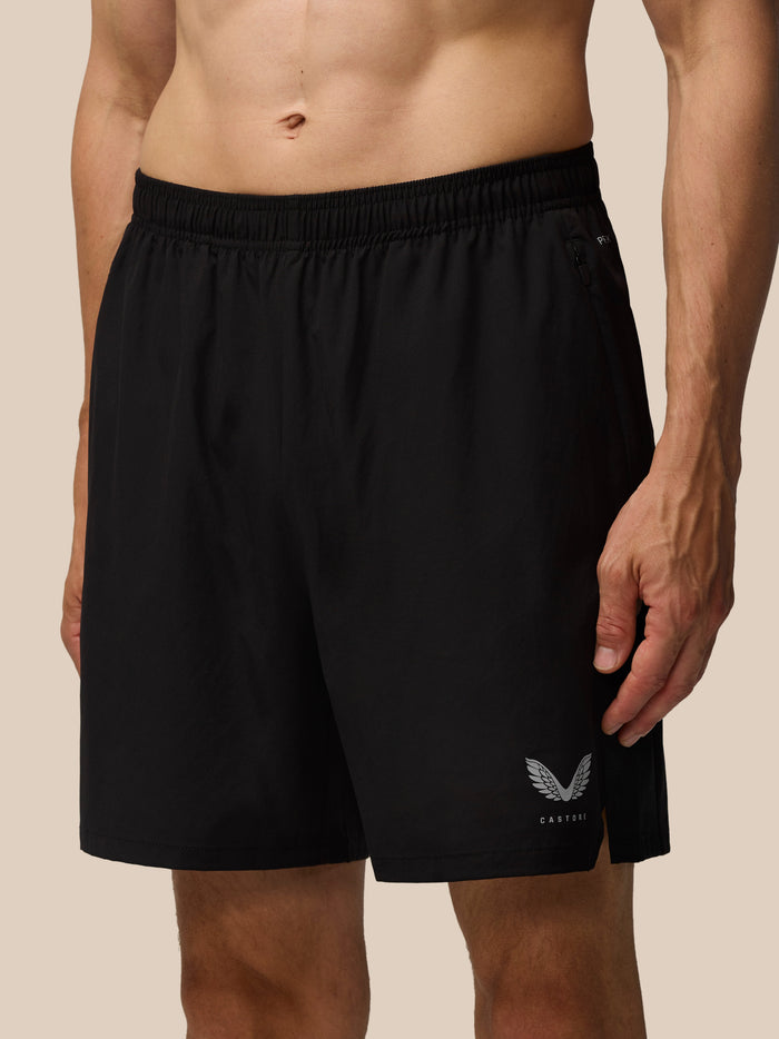 Close-up of a man wearing black Apex Training shorts, highlighting the elastic waistband side zip pocket and Castore logo.