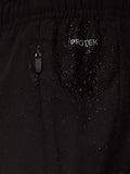 Close up of black Apex Training shorts fabric with ProTek logo, water droplets, and a zipper pull.