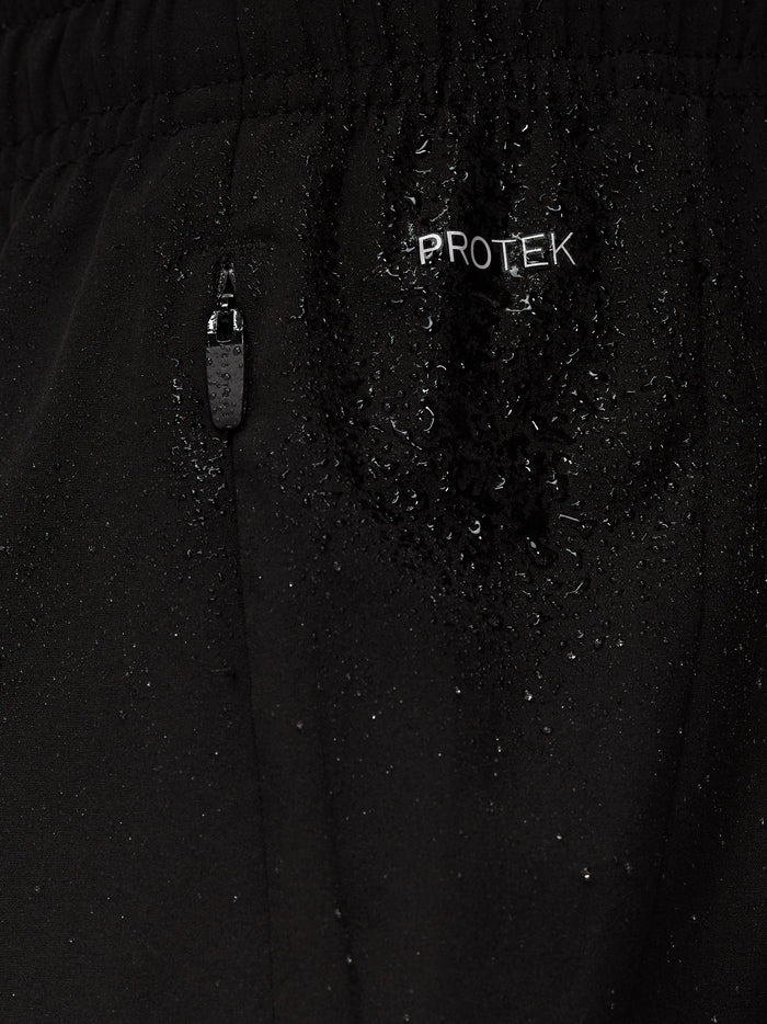 Close up of black Apex Training shorts fabric with ProTek logo, water droplets, and a zipper pull.
