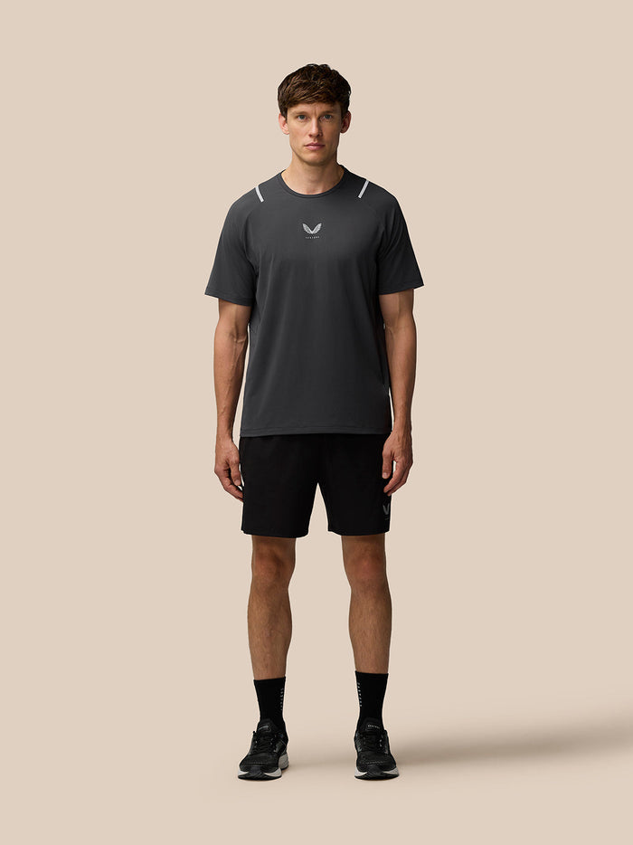 Male model wearing Apex Training T Shirt Gunmetal with reflective shoulder accents, full body front view.