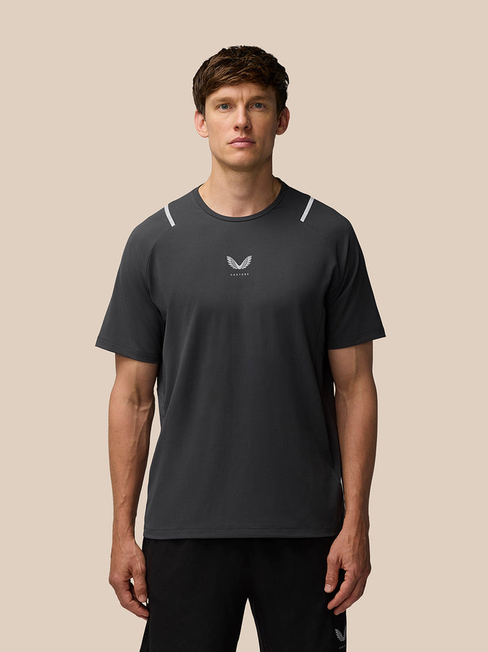Male model wearing Apex Training T Shirt in gunmetal with reflective shoulder accents and Castore logo on the chest