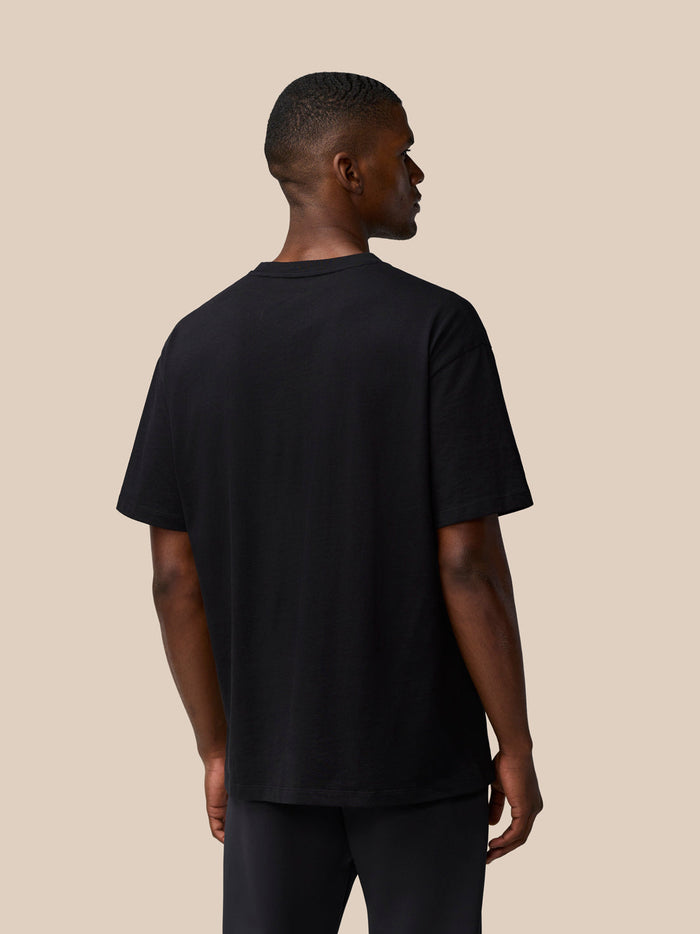 Back view of a male model wearing a black Flex Cotton T Shirt with short sleeves.