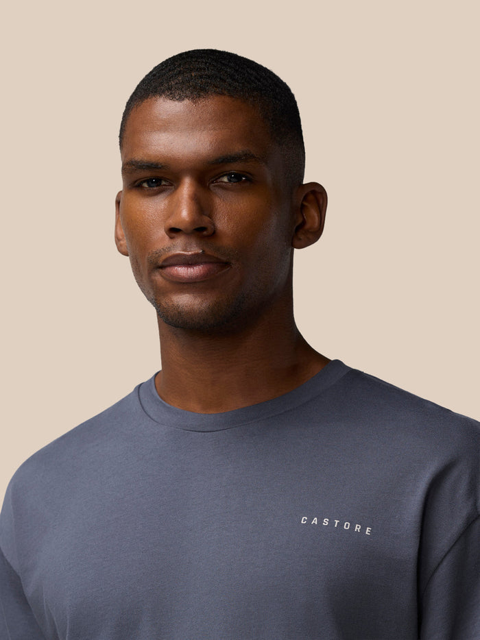 Close-up of a man wearing a pewter gray Flex Cotton T Shirt with a CASTORE logo on the chest