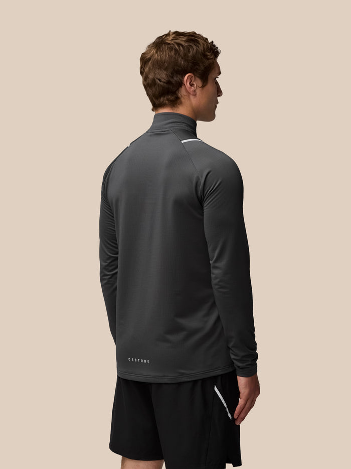 Back view of male model in charcoal Apex Training Winterised quarter zip top highlighting slim fit and grid textured fabric.