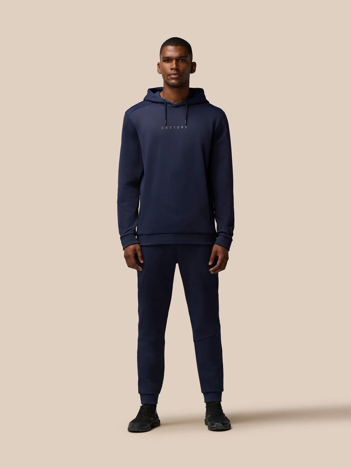 Male model wearing navy Flex Lifestyle Thermo Hoodie with matching joggers and Castore branding.