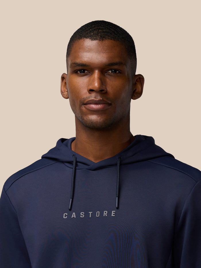 Detail shot of navy hoodie chest with Castore logo and drawstrings.
