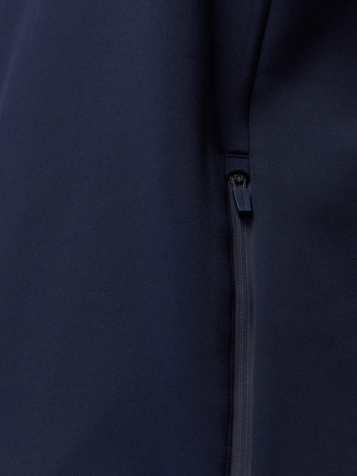 Close up of a navy zip on the hoodie with a branded zipper pull.