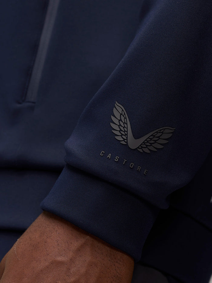 Close up of navy hoodie sleeve featuring Castore logo on the left cuff.