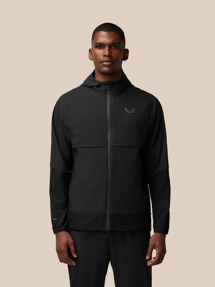 Front view of a man wearing a black Flex Winterised jacket with a hood and chest logo