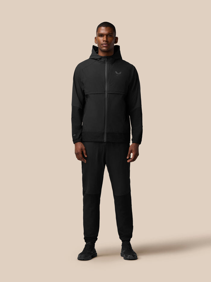 Three quarter rear view of black Flex Winterised Woven Jacket, hood down, highlighting textured lower sleeves.