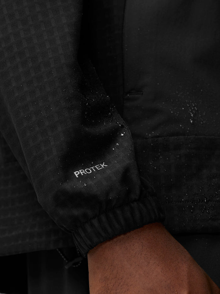 Close up of the black jacket sleeve with the PROTEK branding near the cuff.