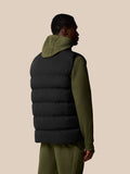 Back view of a black heavyweight padded gilet worn over an olive green hoodie