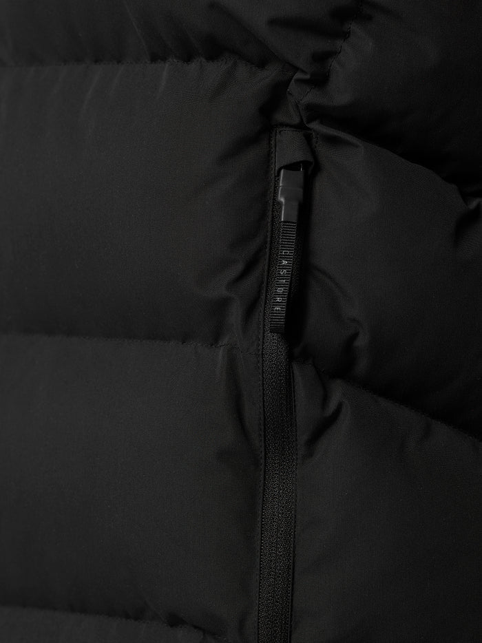 Close-up of a vertical zipper on a black padded gilet with quilted panels.