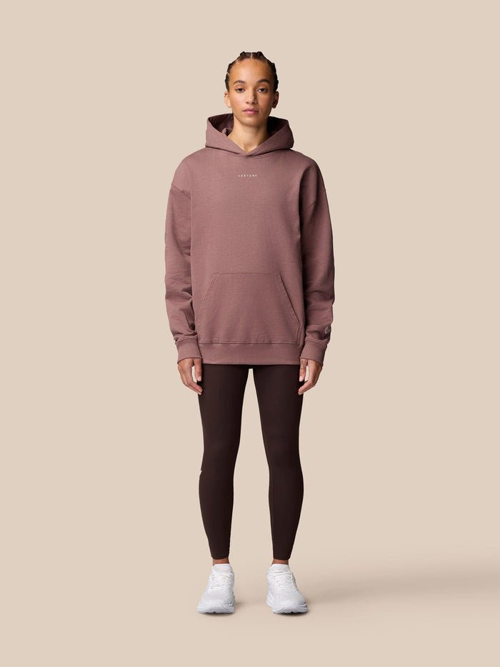 Front view of a model wearing the Adapt Lifestyle Hoodie Mauve with hood and front pocket.