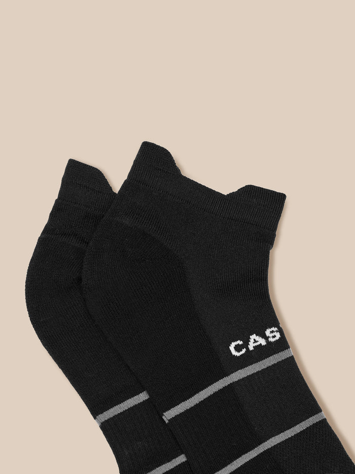 Close-up of black athletic socks featuring Castore branding and grey stripes