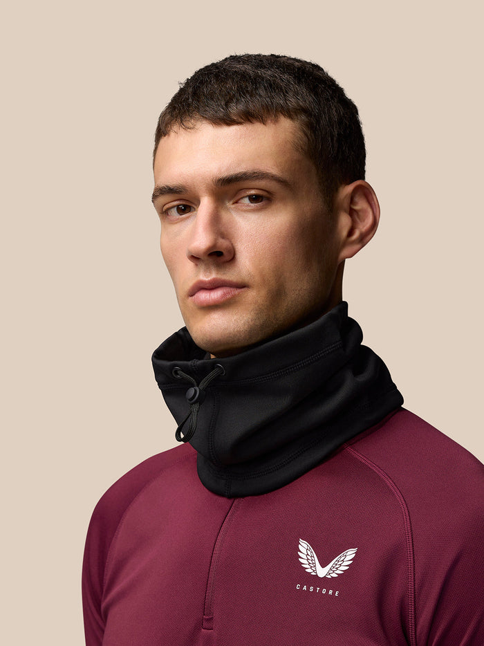 Male model wearing black Active Snood with a drawstring toggle over a burgundy athletic top