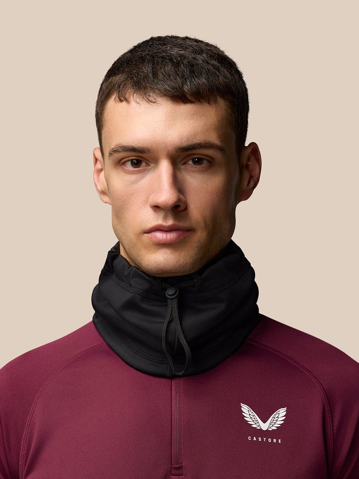 Male model wearing black Active Snood pulled up around the neck and chin over burgundy top