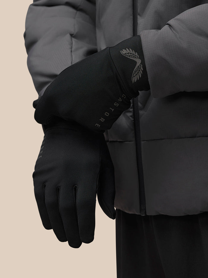 Model wearing a black Castore glove with wing logo on the cuff and CASTORE branding on the side