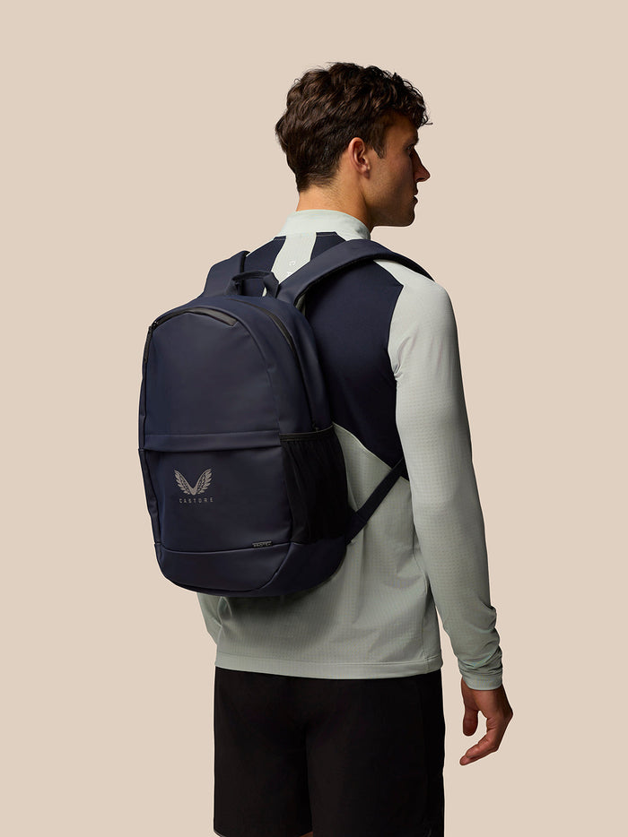 Profile view of a person wearing the navy Castore Active Small Backpack