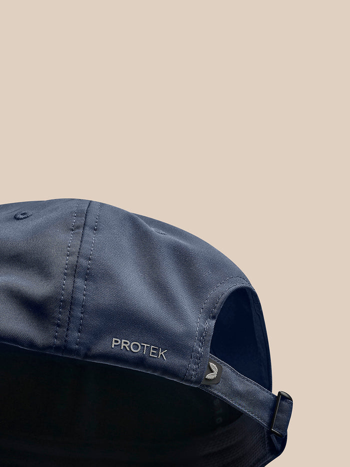 Close-up of navy nylon cap featuring PROTEK branding, visible stitching, and an adjustable back strap