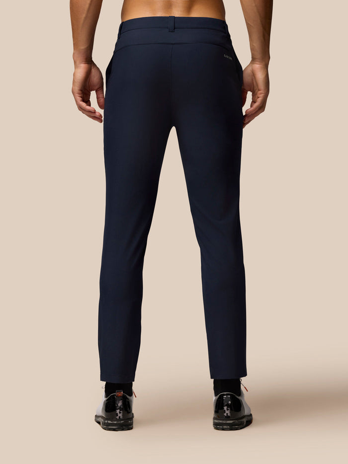 Back view of midnight navy golf trousers on a male model showing a welt back pocket and waist belt loops.