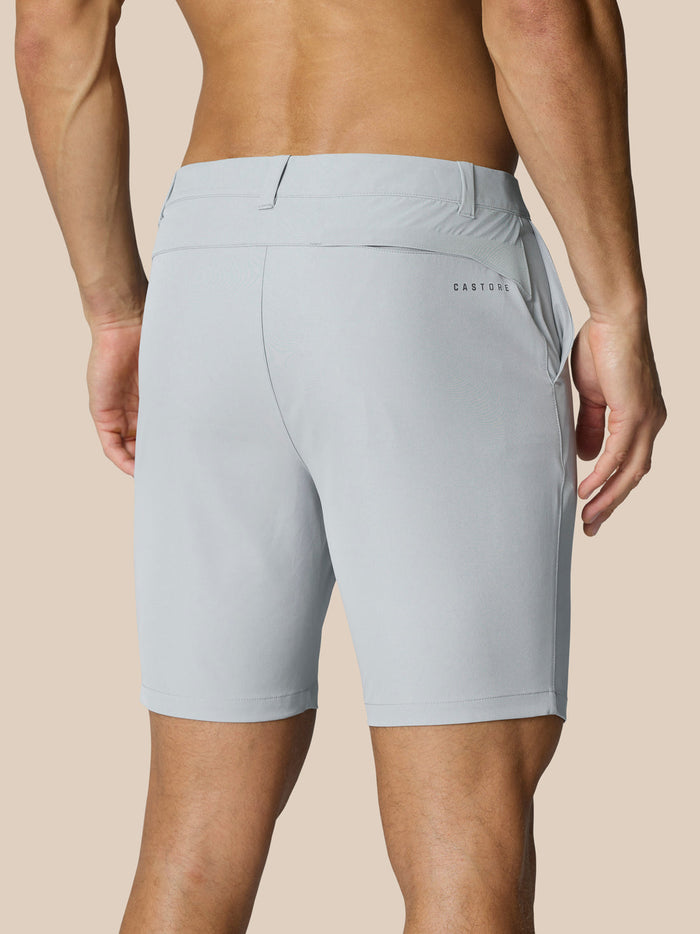 Back view of light grey golf shorts on a male model showing belt loops and a right rear pocket with Castore branding