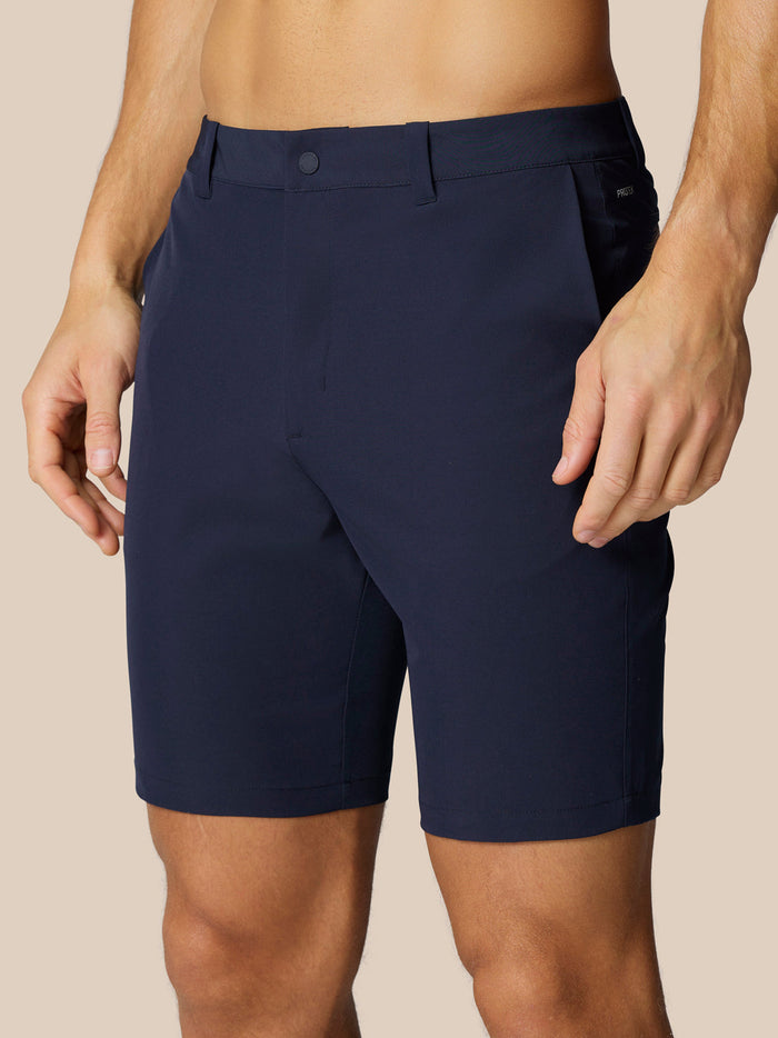 Male model wearing navy Golf Club shorts with belt loops and side pockets, Castore branding on right thigh