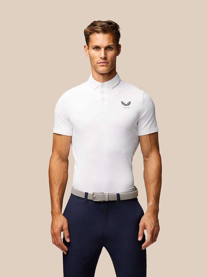 Three-quarter back view of model in white polo showing Castore branding on the upper back and Aertek label at the lower back.
