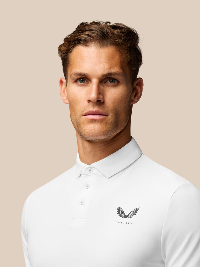 Close up of the polo hem with Aertek branding at the lower back on a white Golf Club Essential Polo.