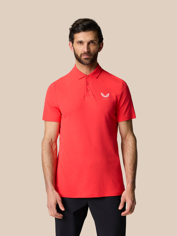 Man in Golf Club Essential Polo in poppy red with Castore logo on the chest