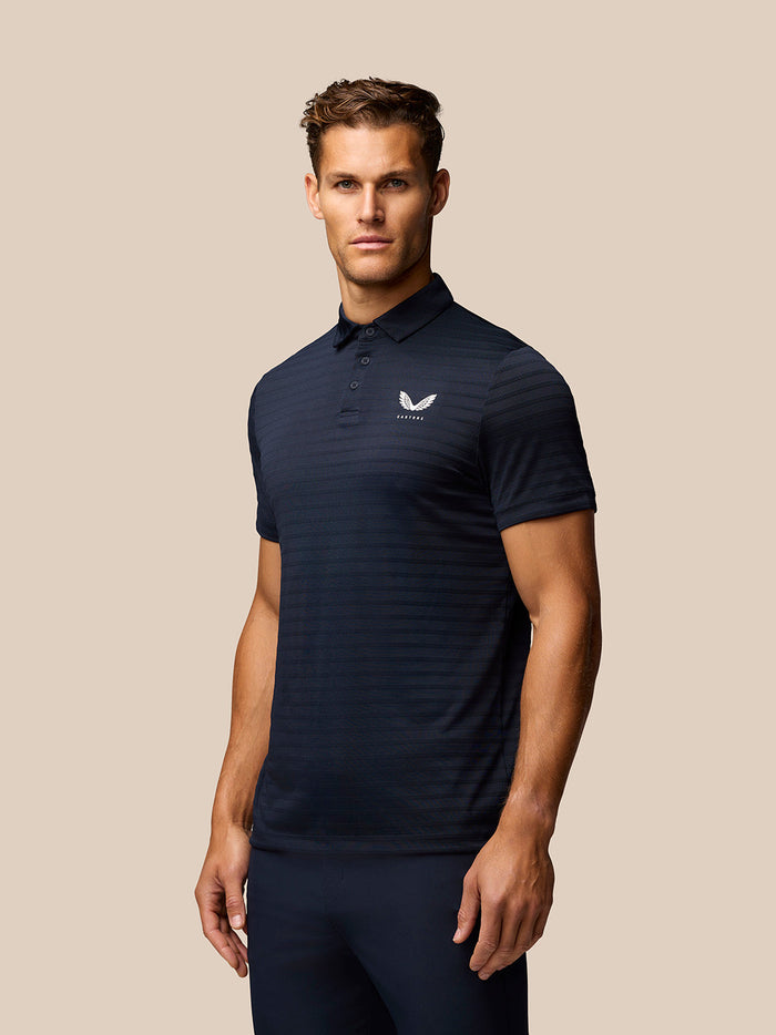 Front view of man wearing navy Pinnacle Pique Stripe Polo with polo collar and Castore logo on chest