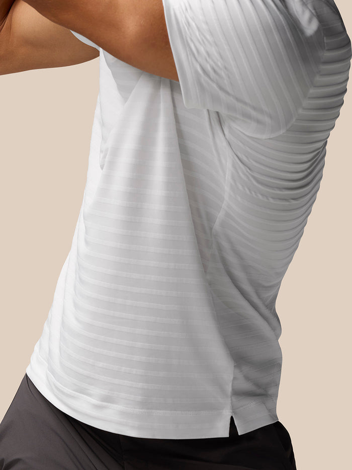 Close up of white textured pique stripe fabric with side hem slit on the polo top