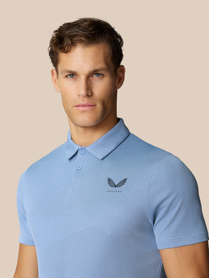 Close up of a male model in sky blue Engineered Knit Polo showing the Castore logo on the chest.