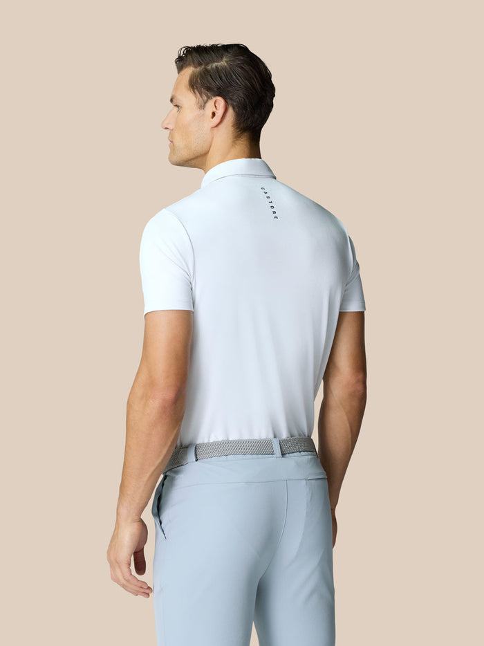 Back view of a man wearing a white golf polo with Castore branding on the upper back