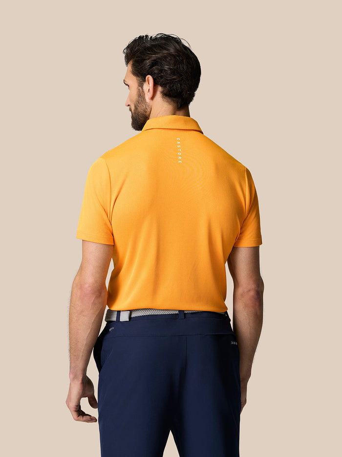 Back view of a male model in the Mango Golf Pinnacle Polo showing Castore branding along the upper back.