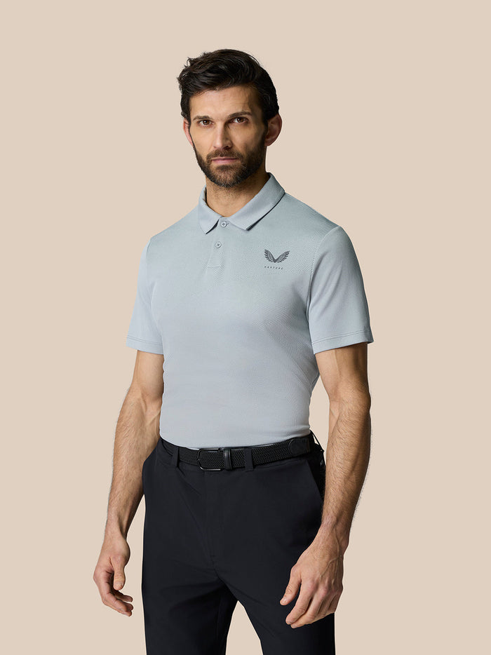 Male model wearing Golf Pinnacle Polo in light grey with breathable knit fabric and chest branding