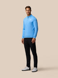 Full body view of a man wearing a light blue Golf Club Classic 1/4 Zip Top with black trousers and white sneakers in a three-quarter pose
