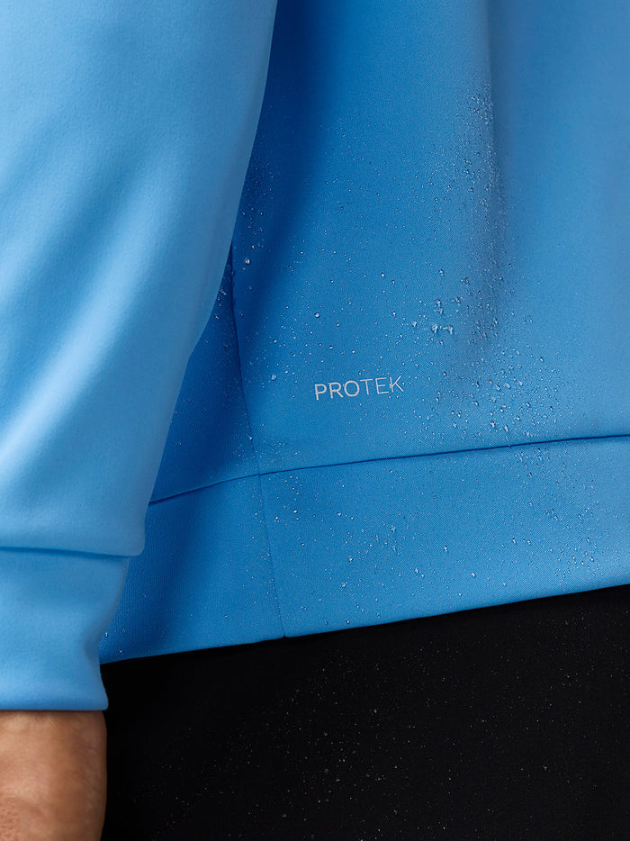 Close-up of blue ProTek fabric with water droplets on the Golf Club Classic Top