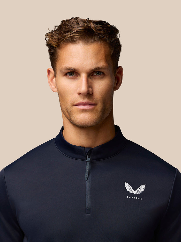 Close-up of navy Golf Club Classic 1/4 Zip Top showing stand collar and left chest logo