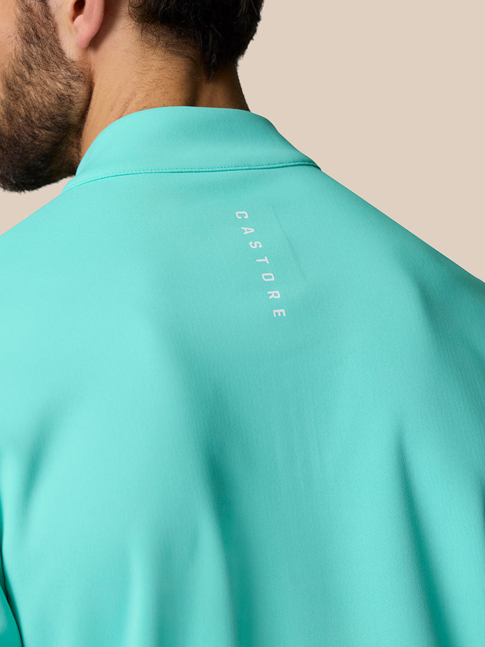 Back view of the light aqua Golf Club Classic Quarter Zip Top with Castore branding along the upper back.