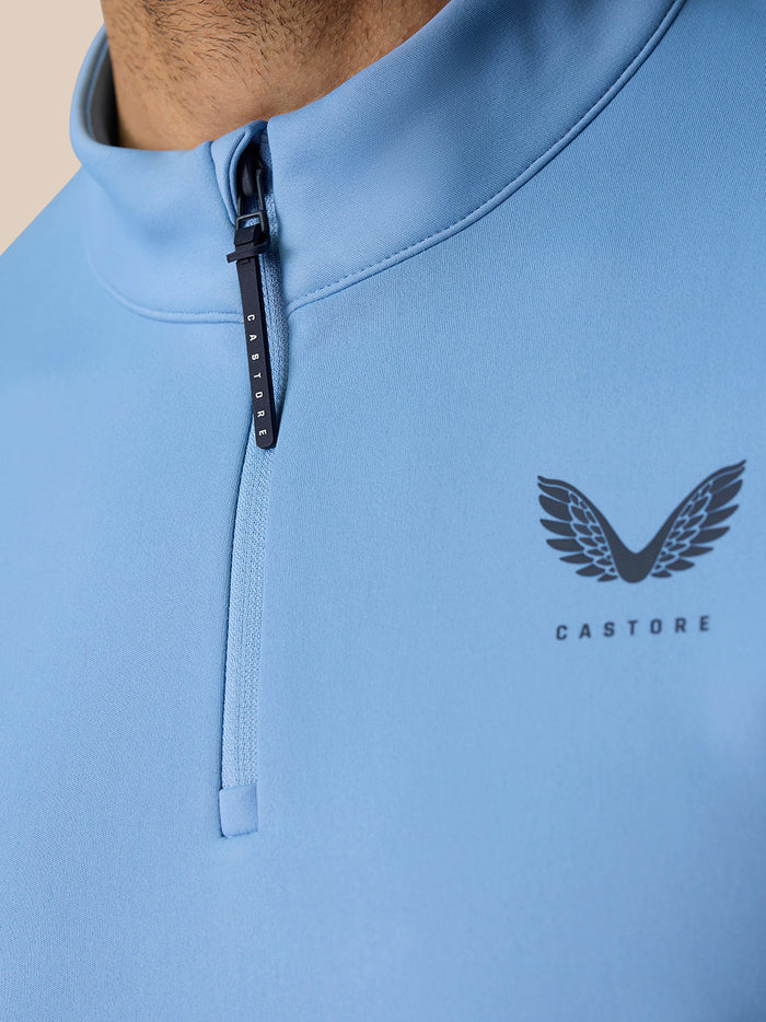 Front detail of the sky blue Golf Club Classic Quarter Zip Top showing center zipper and Castore logo on left chest