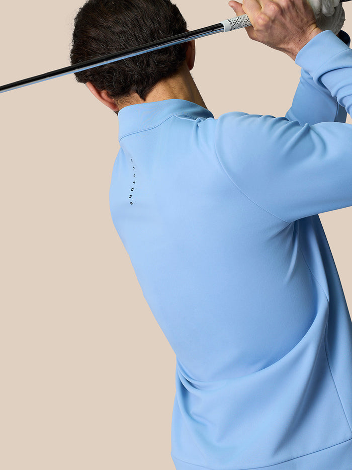 Back view of a person wearing the sky blue Golf Club Classic Quarter Zip Top with stand collar and Castore branding on the back