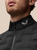 Close-up of black stand collar golf gilet with a silver wing logo near the zipper.
