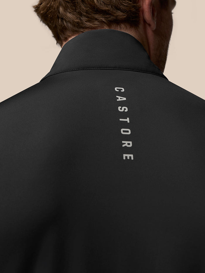 Close-up of the black vest collar with a silver Castore wing logo and zipper