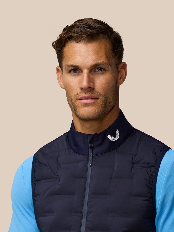 Male model wearing Golf Pinnacle Gilet in Midnight Navy with stand collar and full front zip.