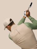 Side view of golfer wearing Golf Pinnacle Mushroom gilet with beige front and green sleeves, swinging a club