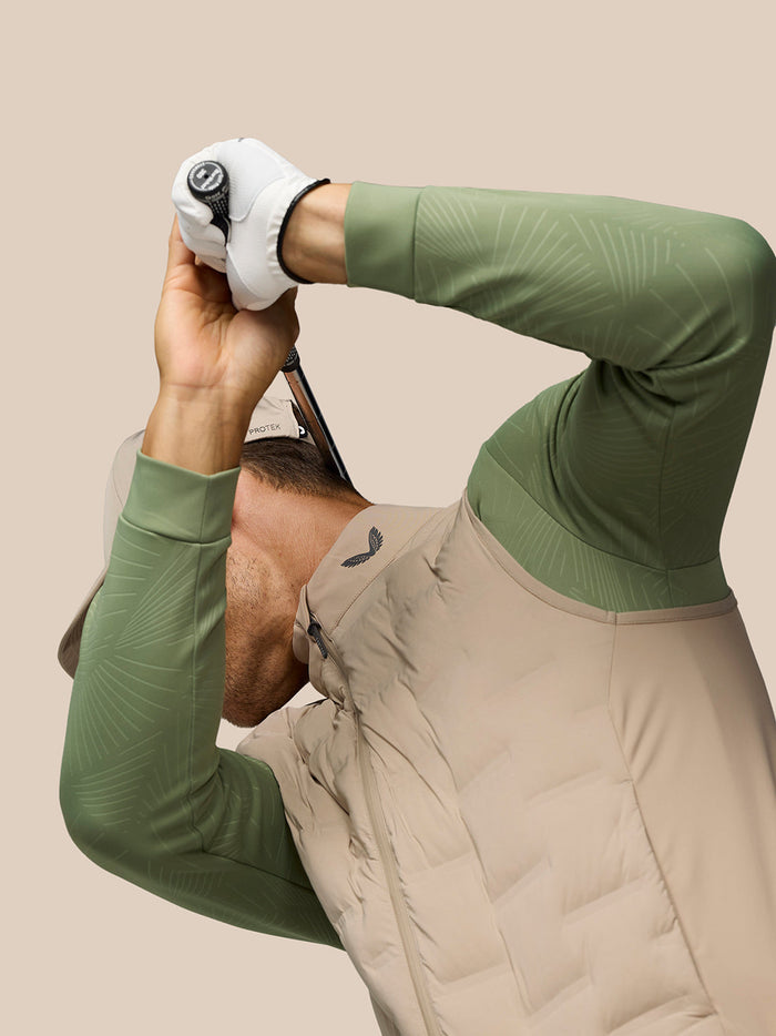 Side profile of a male model wearing Mushroom Golf Pinnacle Lightweight Hybrid Gilet with quilted front